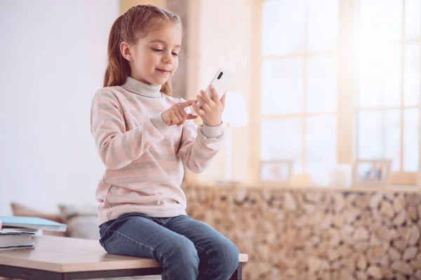 Мила дівчина вчиться користуватися смартфоном — стокове фото