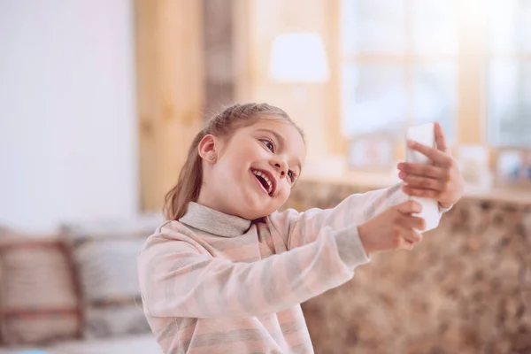 Gelukkig vrolijke meisje op zoek naar de camera van de smartphone — Stockfoto