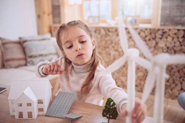 Slimme leuk meisje te kijken naar het model van de windmolen — Stockfoto