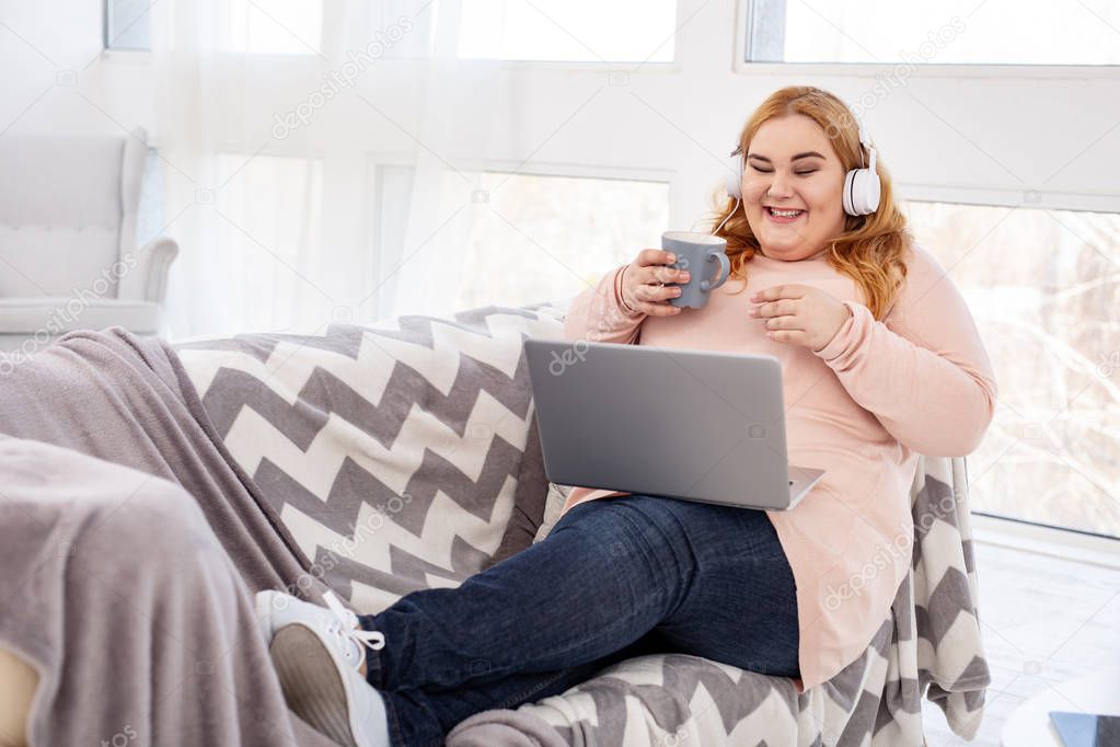 Cheerful overweight woman watching a film