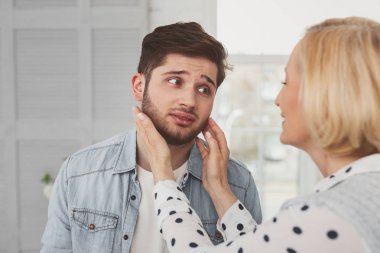 Annesine bakarak üzgün sakallı adam