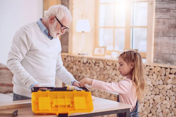 Bella ragazza carina aiutare suo nonno — Foto Stock