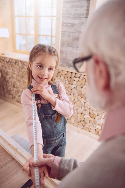 Bella ragazza positiva guardando suo nonno — Foto Stock