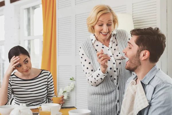 Nöjd äldre kvinna som håller en sked — Stockfoto