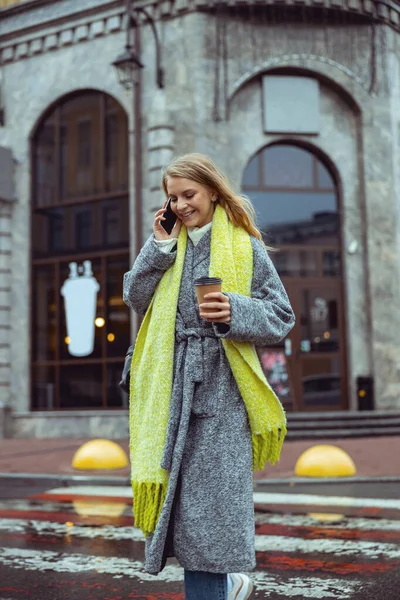 Female using her mobile phone at the pedestrian crossing