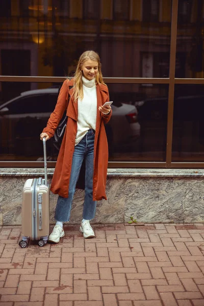 Mujer con una bolsa de viaje de pie fuera — Foto de Stock