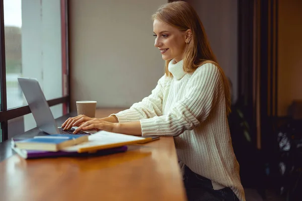 Bájos nő dolgozik a laptopját beltérben — Stock Fotó