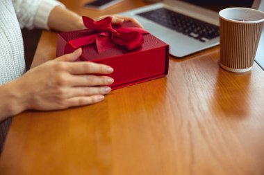 Masada bir hediyeyle oturan kadın.