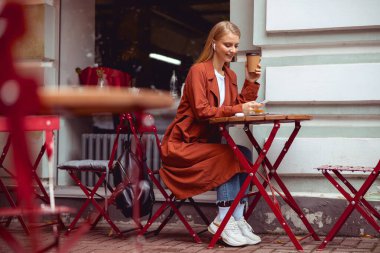 Good-looking girl with a cup of coffee outdoors