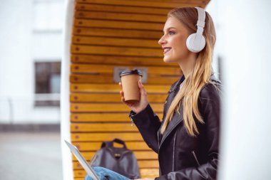 Elinde bir fincan kahve tutan şık bir bayan.