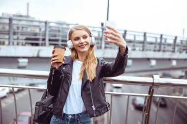 Güzel bayan dışarıda kameraya poz veriyor.