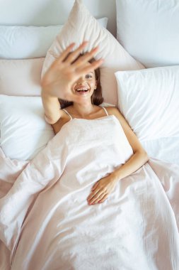 Neşeli esmer kız avucunu kameraya kaldırıyor.