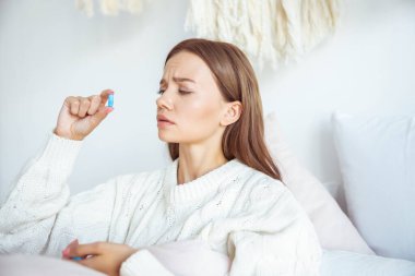 Konsantre esmer kız mavi tablete bakıyor.