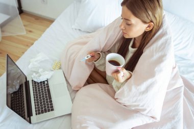 Termometreye bakan nazik bir kadın.