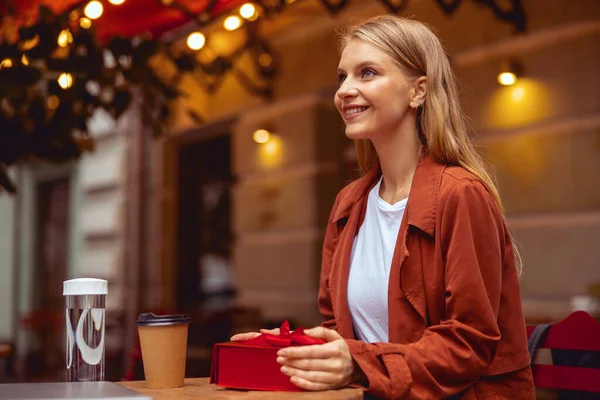 Gelukkig meisje wachten op iemand in een cafe — Stockfoto