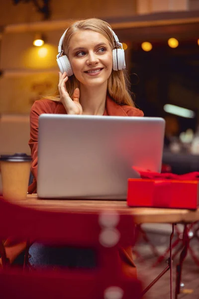 Задоволена дівчина слухає музику за столом — стокове фото
