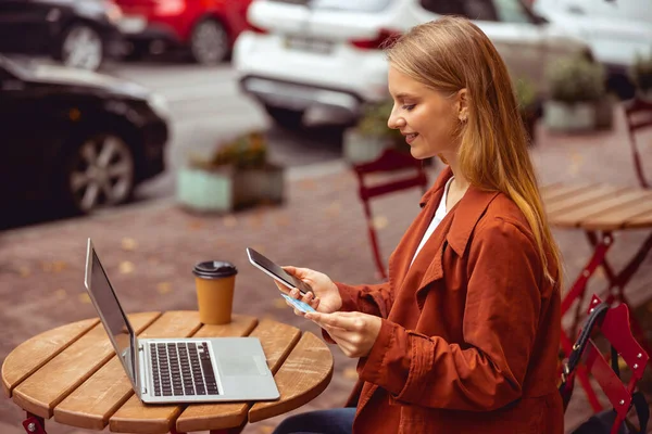 Feminino segurando um telefone celular e cartão — Fotografia de Stock