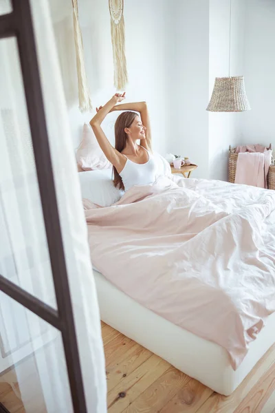 침대에 앉아 행복 한 젊은 여성 — 스톡 사진