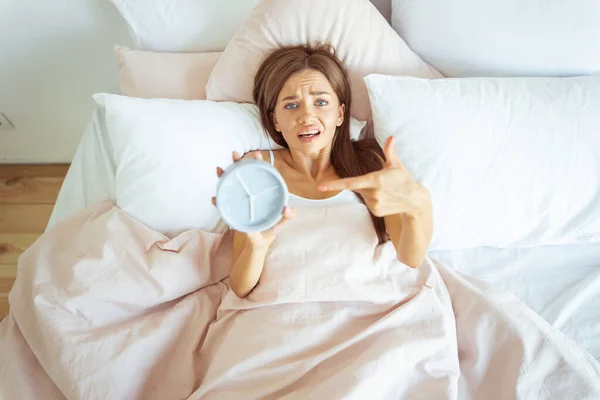 Negativo encantado joven mujer acostada en su cama — Foto de Stock