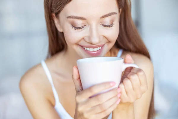 Retrato de morena encantadora que mirando en su taza — Foto de Stock