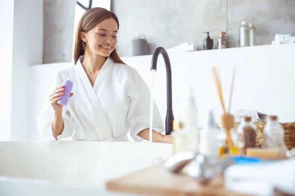 Positiv beglücktes Mädchen gießt Wasser in Badewanne — Stockfoto