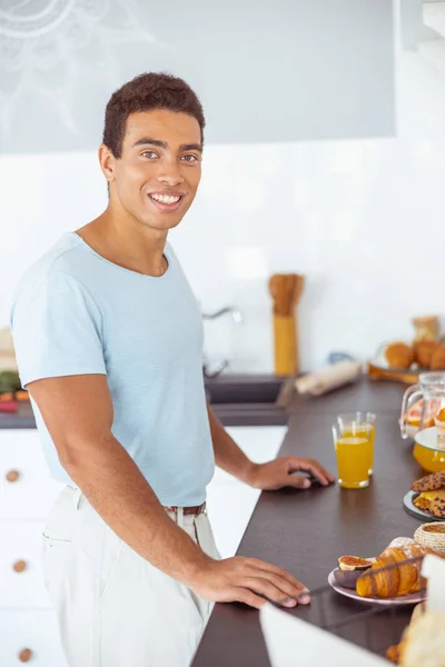 Zadowolony brunetka młody człowiek mając czas na śniadanie — Zdjęcie stockowe