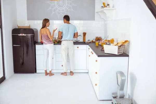 Man och kvinna lagar frukost i sitt kök — Stockfoto