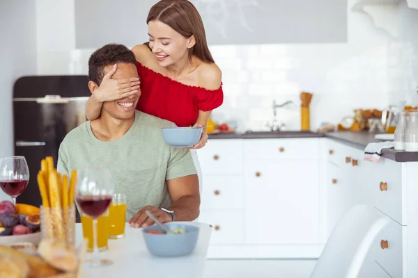 Menina encantada positiva cobrindo os olhos de seu parceiro — Fotografia de Stock