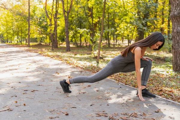 Konzentrierte Frau macht ihre Morgenübungen draußen — Stockfoto