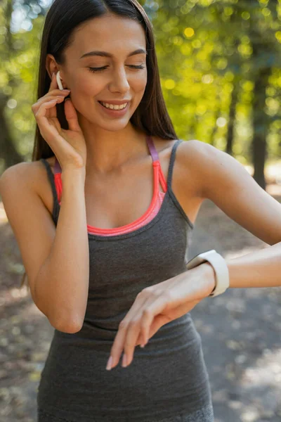 Happy woman deciding which song to choose for jogging — ストック写真