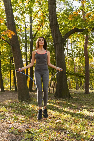 Konzentrierte Sportlerin hüpft beim Training im Park — Stockfoto