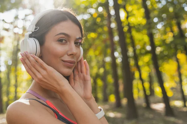 彼女の耳の中で音楽を楽しんでいる陽気な女性 — ストック写真