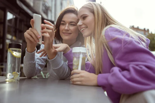 Persona femenina agradable mirando una pantalla de su gadget — Foto de Stock