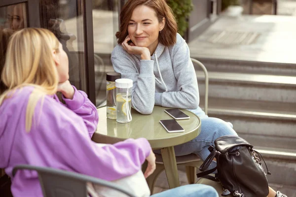 Cheerful young females looking at each other during talk — Stock Photo, Image