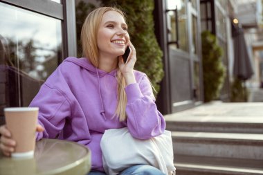 Kahvesini yudumlayan uzun saçlı bir kız.