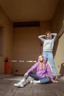 Şık genç dişiler günlük kıyafetlerini sergiliyorlar.