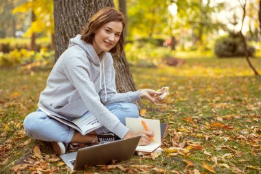 Çekici genç bir bayan doğrudan kameraya bakıyor.
