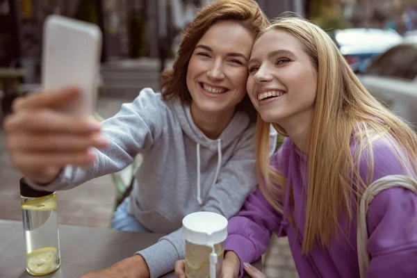 Удивительные молодые женщины сидят на террасе в кафе — стоковое фото