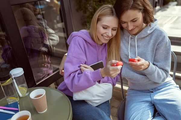 Jovens mulheres agradáveis falando sobre seus gadgets — Fotografia de Stock