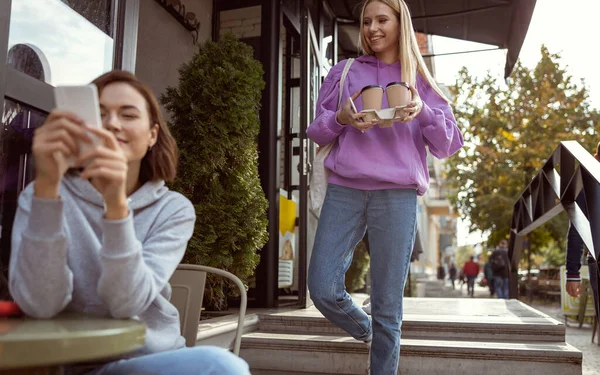 Милая длинноволосая женщина встречается со своей подругой в кафе — стоковое фото