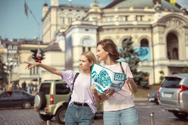 Positivo encantado meninas usando mapa durante a caminhada — Fotografia de Stock