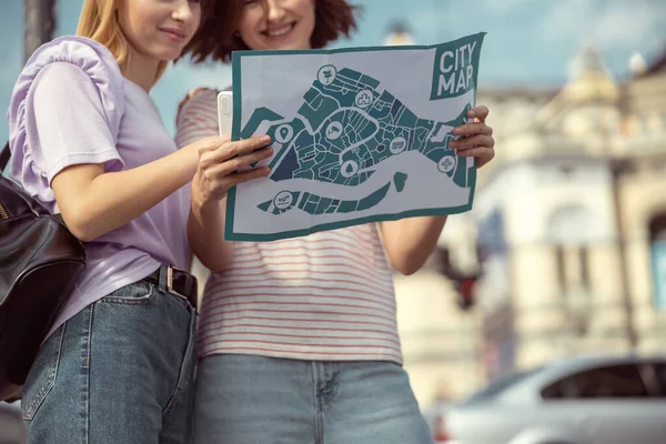 Aangename jonge vrouwen staren naar de stadsplattegrond — Stockfoto