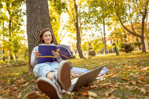 Positivo encantado chica morena lectura gramática tarea — Foto de Stock