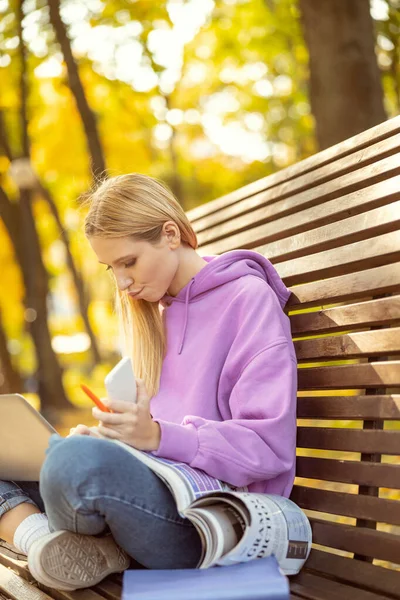 Koncentrerad kvinnlig person stirrar på sin gadget — Stockfoto