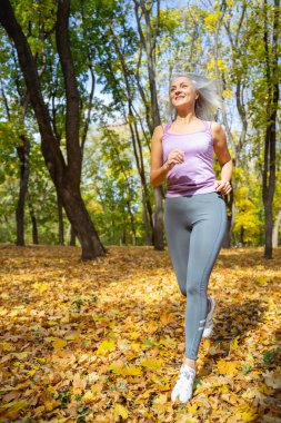 Neşeli, güzel Kafkas koşucusu şık spor kıyafetleri giyiyor.