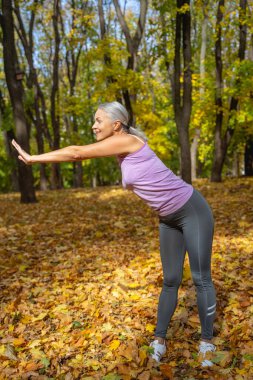 Aktif, ince, memnun bayan dışarıda çalışıyor.