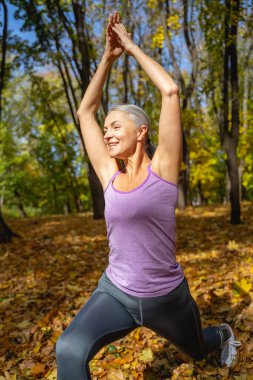 Yoga yapan neşeli olgun bir kadın.