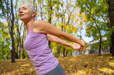 Kolları arkada olan atletik bir bayan.