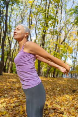 Parkta egzersiz yapan hoş, esnek bir bayan.