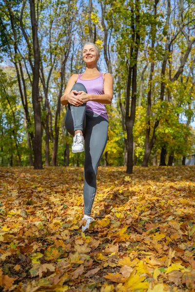 Deportiva mujer estirando sus músculos de la pierna fuera — Foto de Stock